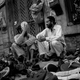 Two shoe sellers await customers on the sidewalk they have made their home.